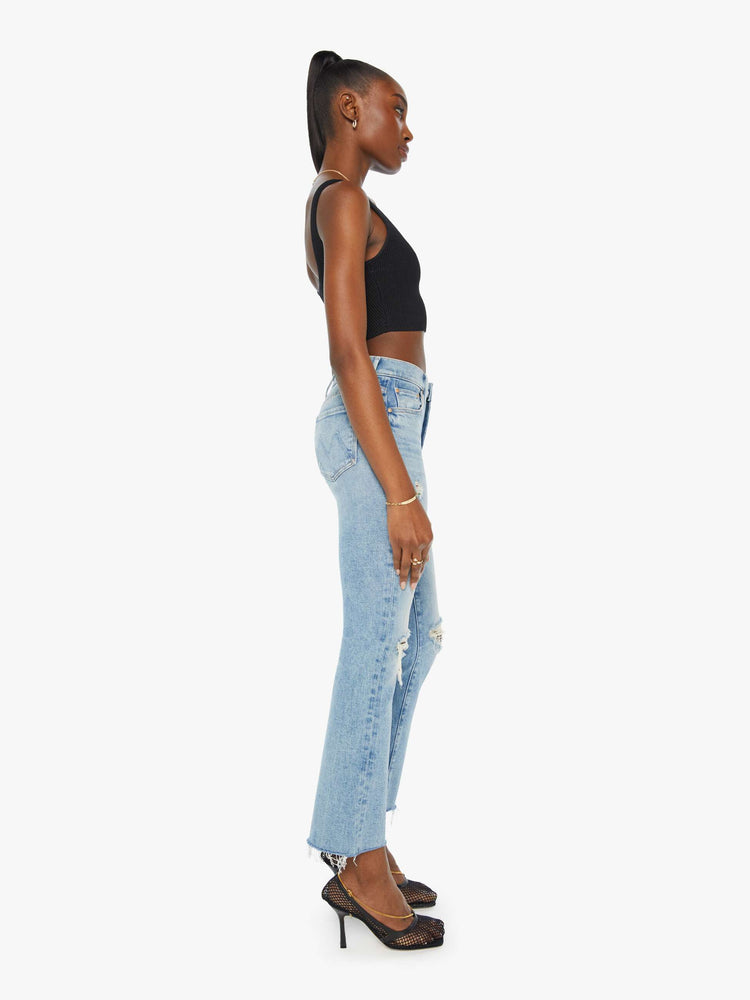 Side view of a woman in light-blue high rise bootcut with a 28.25 inch inseam.