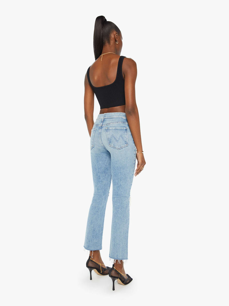 Back view of a woman in light-blue high rise bootcut with a 28.25 inch inseam.