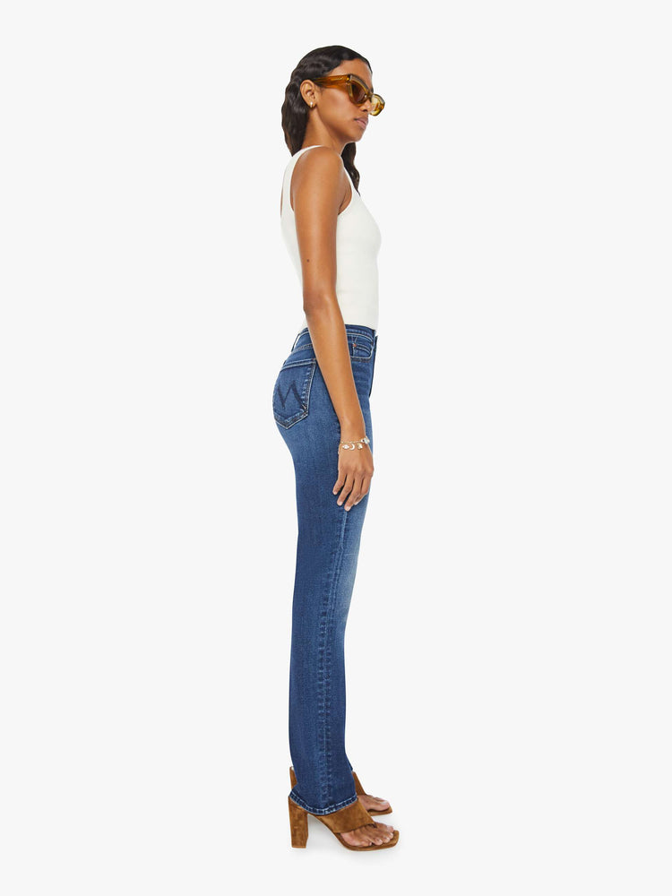 Side view of a woman in dark blue high-rise straight leg with a 32-inch inseam and a clean hem. 