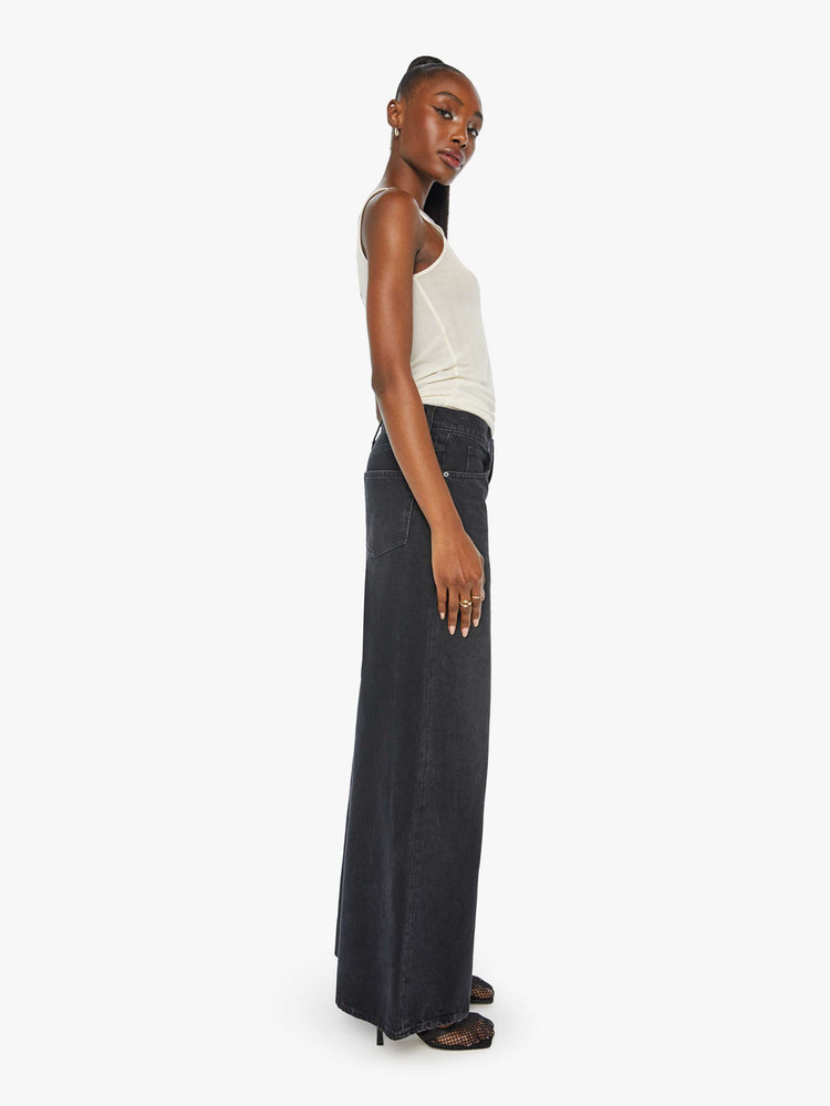 Side view of a woman in faded black slouchy jeans are meant to sit lower on the hips, and feature a loose, full leg and a long 32-inch inseam.