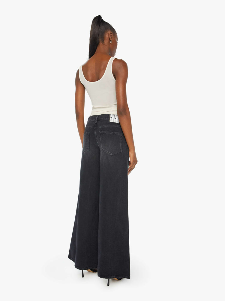 Back view of a woman in faded black slouchy jeans are meant to sit lower on the hips, and feature a loose, full leg and a long 32-inch inseam.