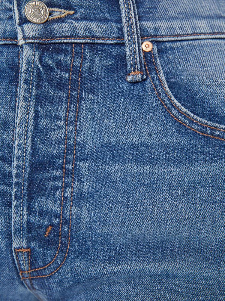 Swatch view of a woman in a mid blue slim straight leg with a mid rise, button fly and low set back pockets and clean hem.