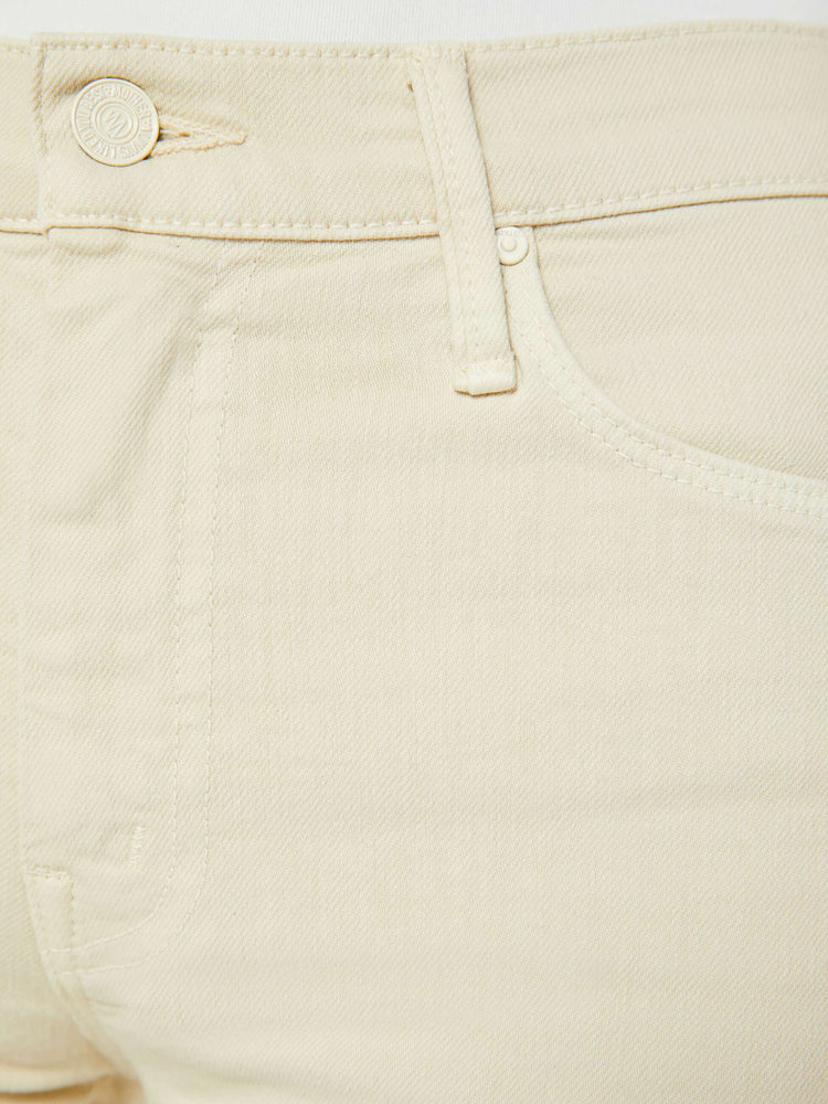 Swatch view of a woman in an off white color flare jean has a mid rise with a 32-inch inseam and a clean hem.