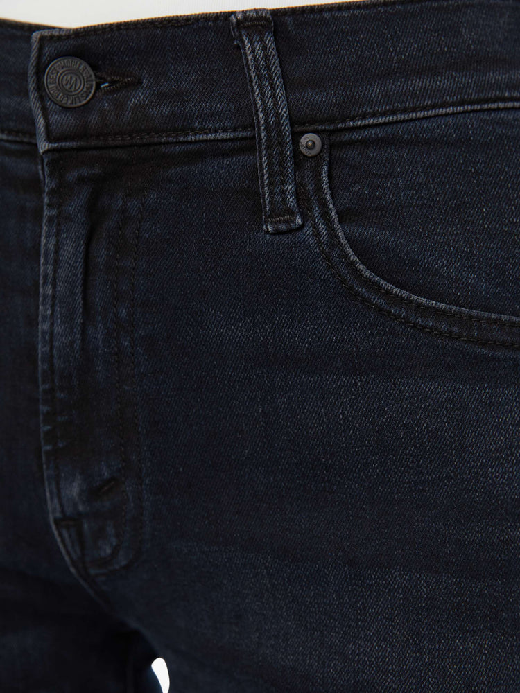 Swatch view of a woman in a dark denim mid-rise jean with a wide straight leg, zip fly and clean ankle-length inseam.