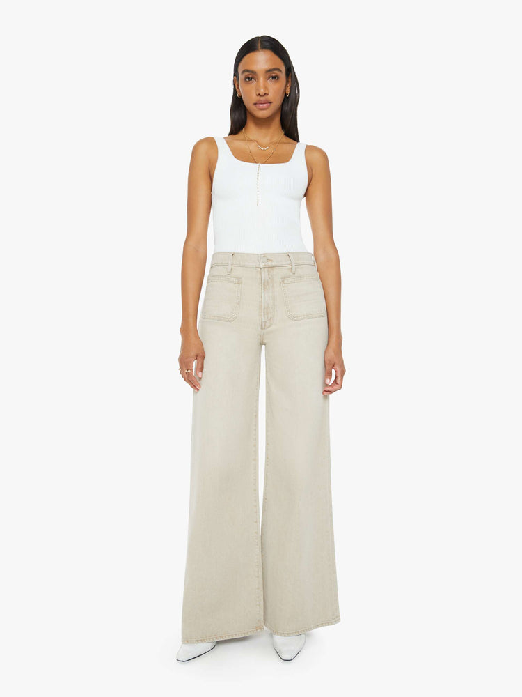 Front view of a woman in a light khaki wide leg pant with a high rise, long 32-inch inseam, patch pockets and a clean hem.