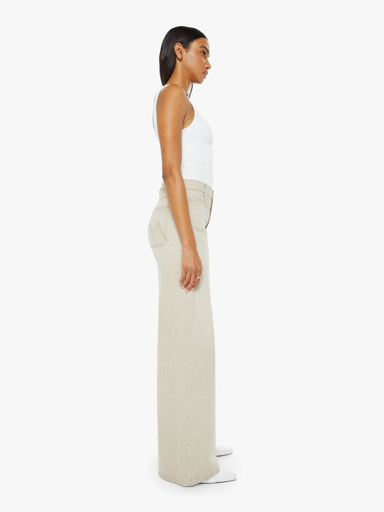 Side view of a woman in a light khaki wide leg pant with a high rise, long 32-inch inseam, patch pockets and a clean hem.