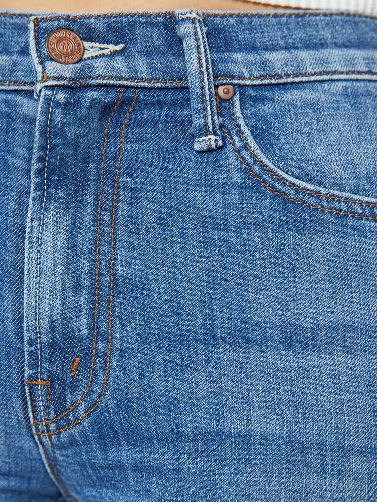 Swatch view of a woman in a high-waisted bootcut has a 32-inch inseam and a clean hem in a mid blue wash.