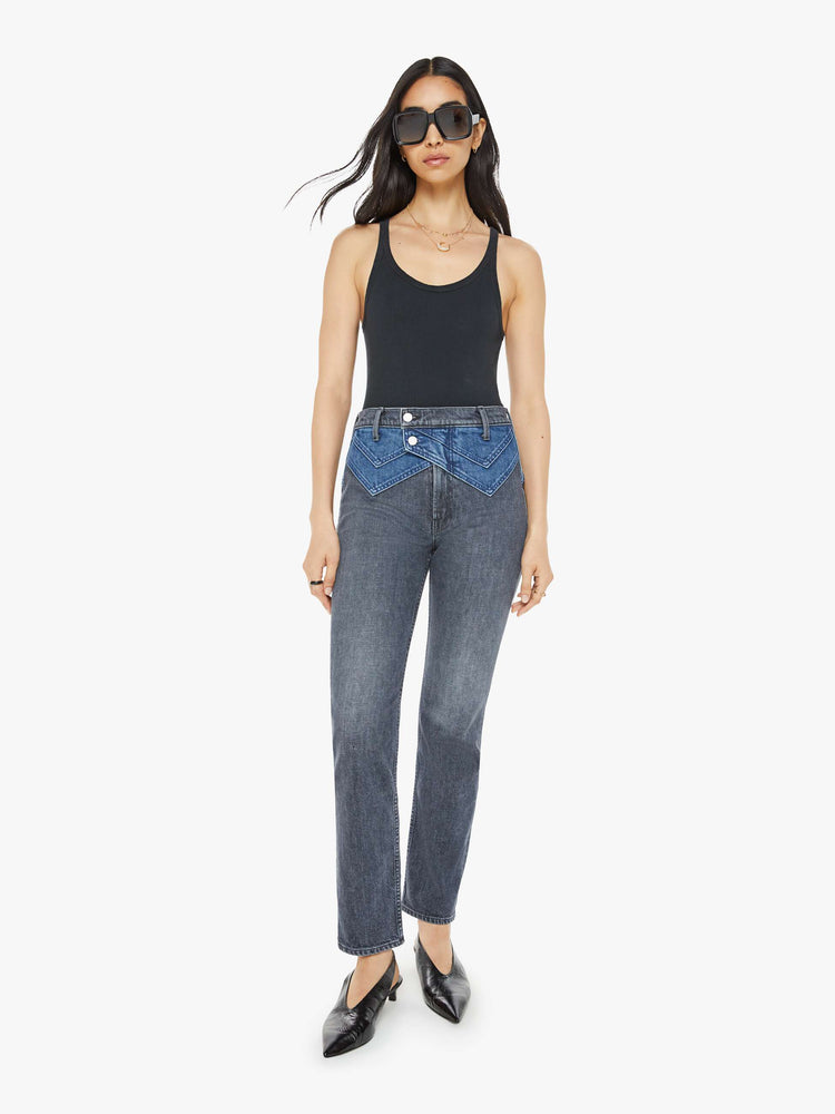 Front view of a woman in black and blue high-waisted jeans with a narrow straight leg, 2-button waistband, 30-inch inseam and a clean hem.