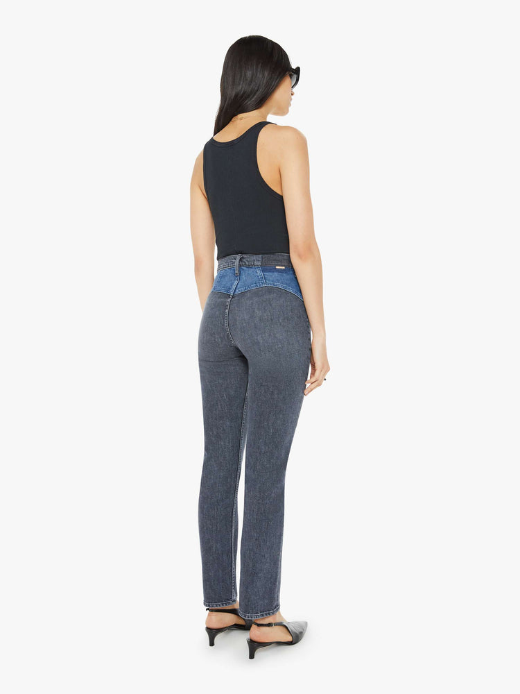 Back view of a woman in black and blue high-waisted jeans with a narrow straight leg, 2-button waistband, 30-inch inseam and a clean hem.