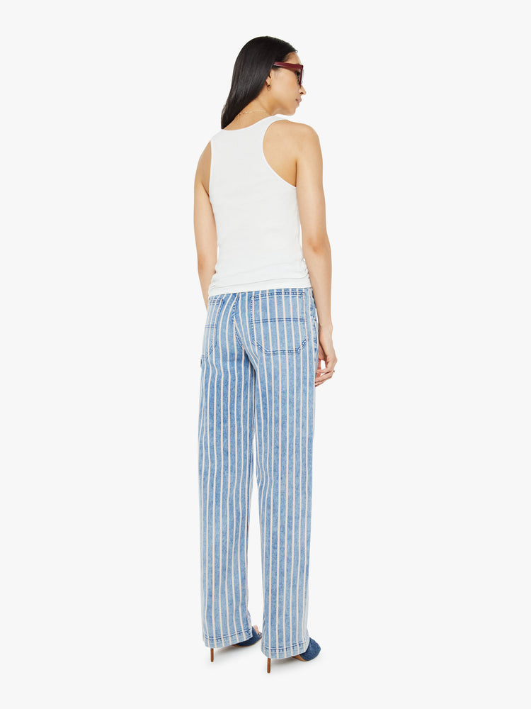 Back view of a woman in a super high-waisted pants with a loose, straight leg, utility-inspired patch pockets, hammer loop and a long inseam in light blue with white stripes.