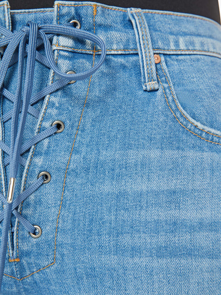 Swatch view of a woman in a mid blue high-rise straight leg with a lace-up fly, 29-inch inseam and a clean hem.