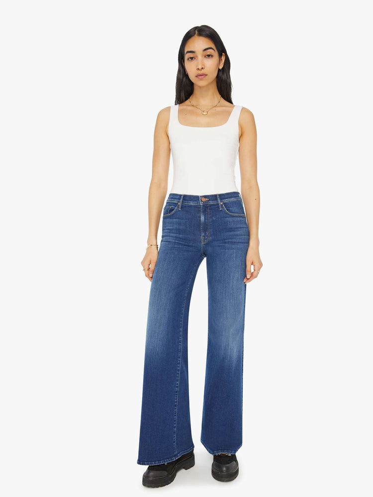 Front view of a woman flared, wide-leg jean with a high rise and a clean, 32-inch inseam in a mid blue wash.