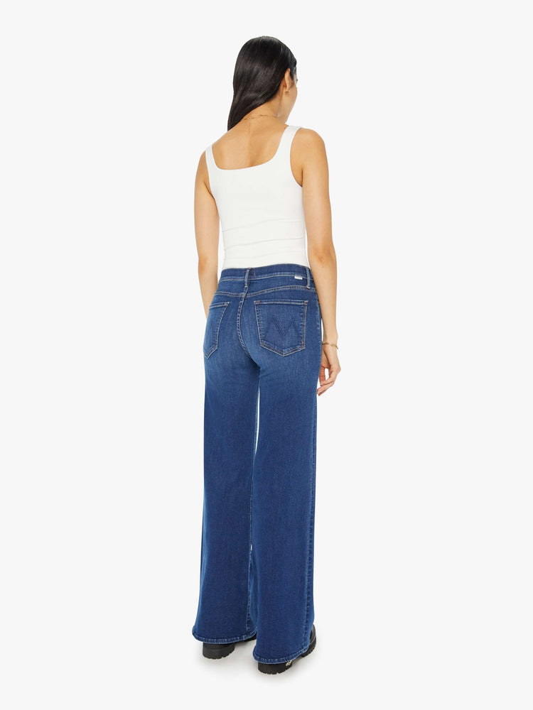 Back view of a woman flared, wide-leg jean with a high rise and a clean, 32-inch inseam in a mid blue wash.