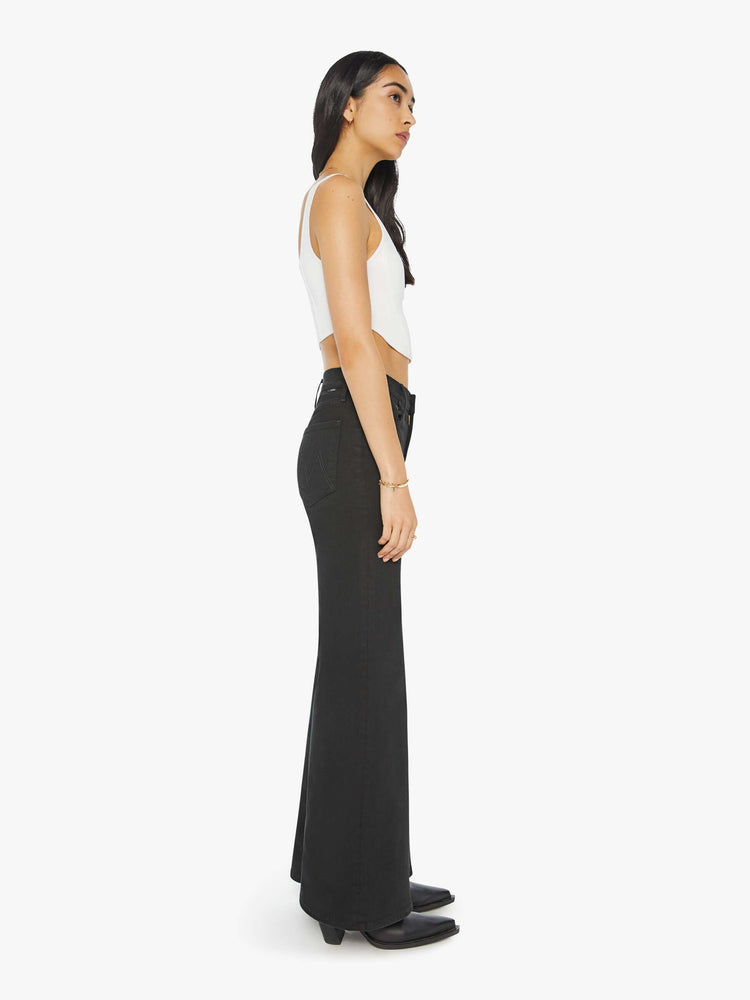 Side view of a woman flared, wide-leg jean with a high rise and a clean, 32-inch inseam in a solid black.