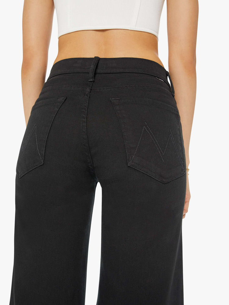 Back view of a woman flared, wide-leg jean with a high rise and a clean, 32-inch inseam in a solid black.