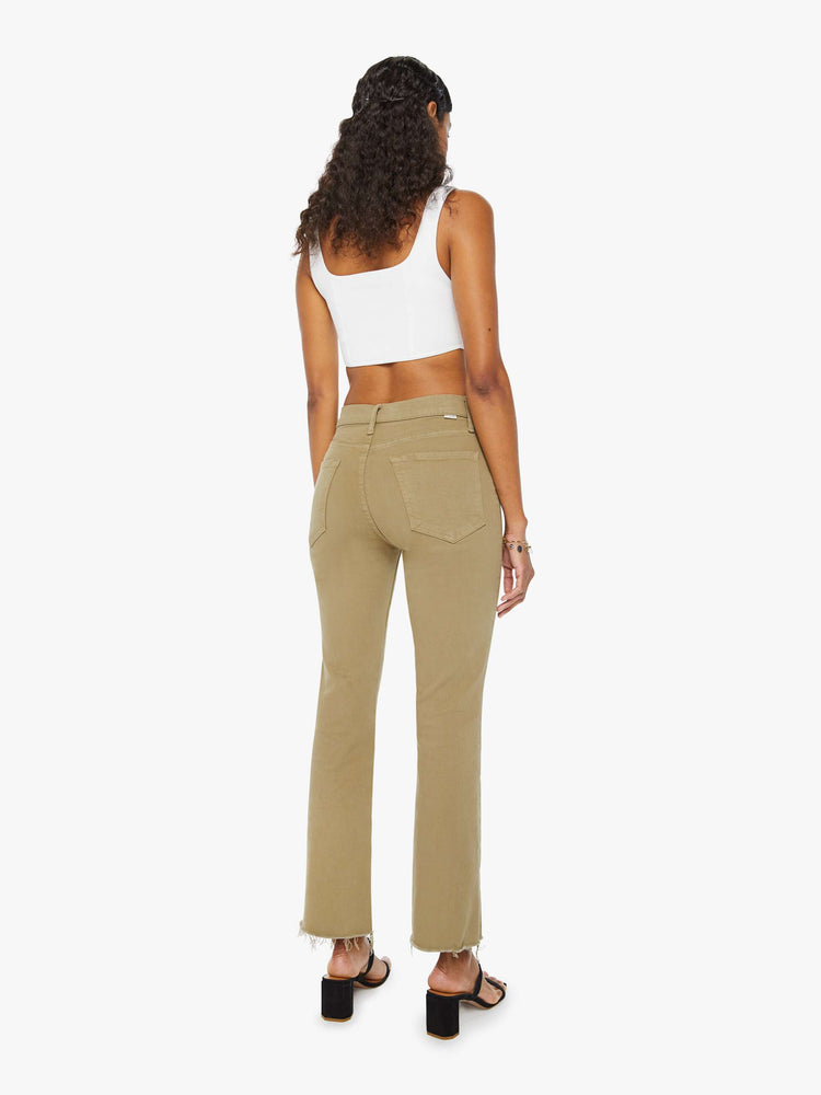 Back view of a woman in warm khaki high-rise flare with a button fly and a frayed hem.