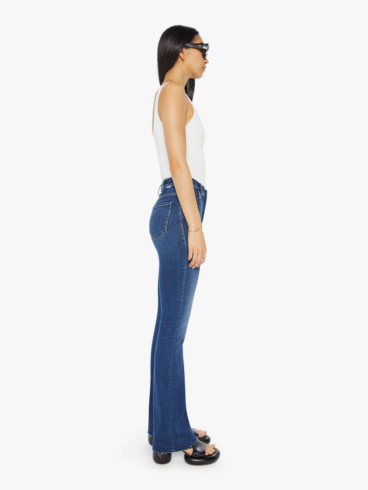 Side view of a high waisted bootcut jean in a dark blue jean.