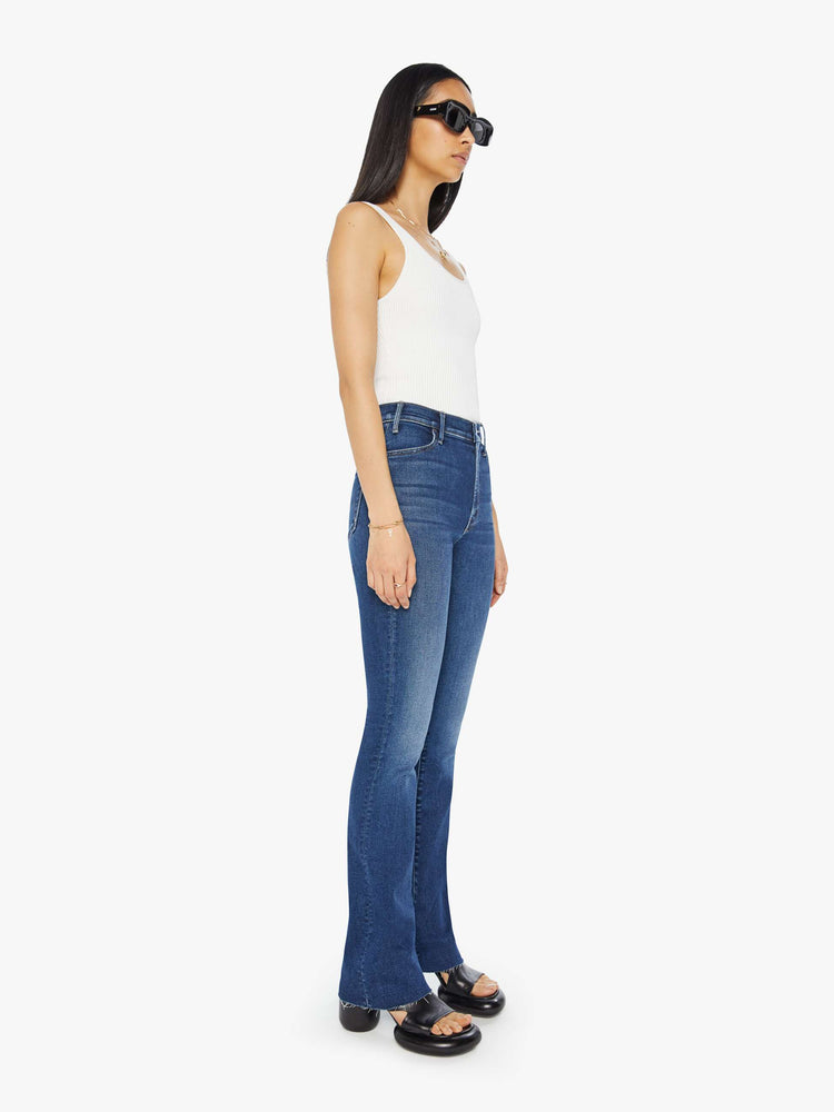 Side angle view of a high waisted bootcut jean in a dark blue jean.