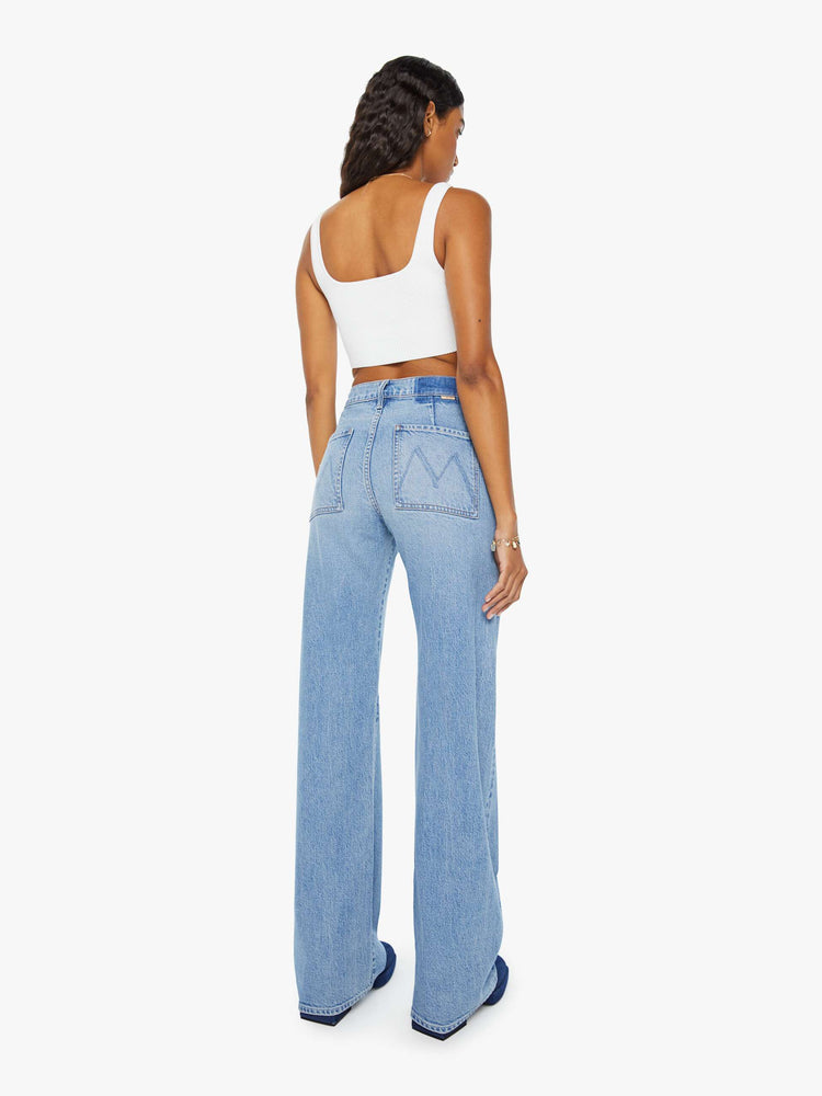 Back view of a woman wide-leg jeans with a super high rise, patch pockets and a long 34-inch inseam with a clean hem in a light blue wash.