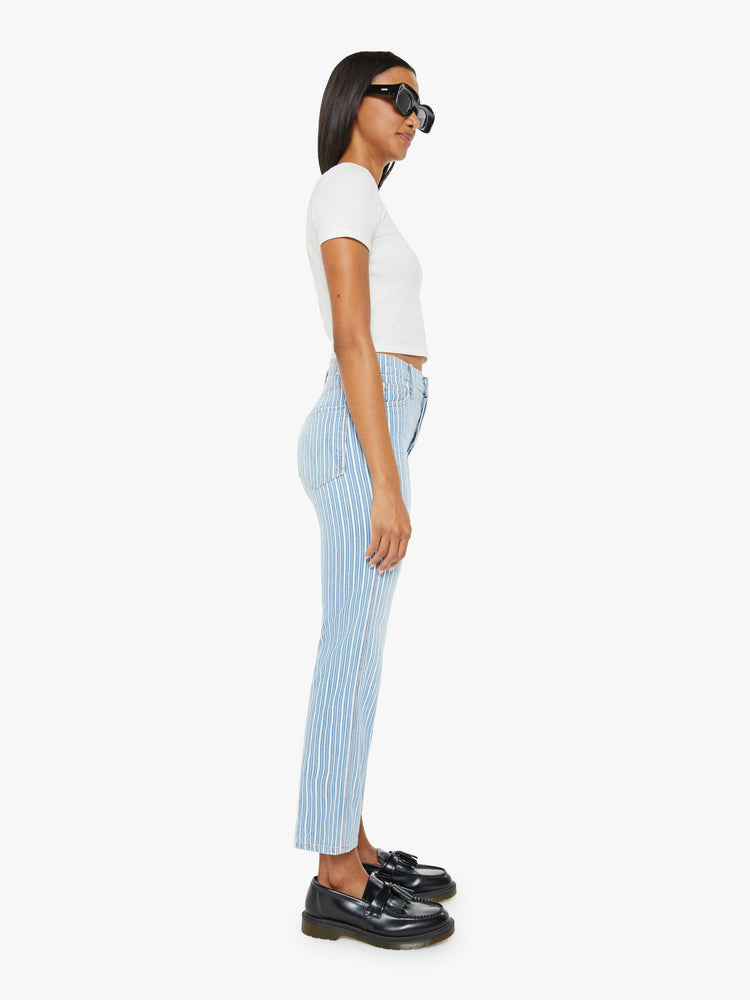 Side view of a woman in a High-rise jeans with a straight leg, button fly, ankle-length inseam and a clean hem.