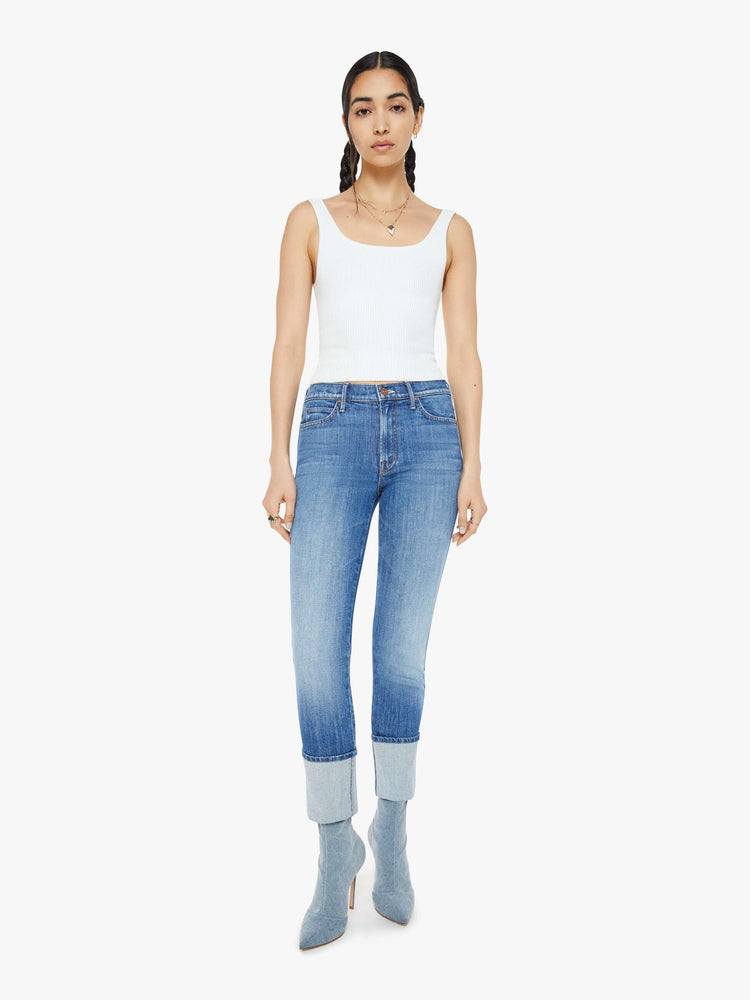 Front view of a woman in a mid blue high-rise straight-leg jeans with an ankle-length inseam and a clean, cuffed hem.