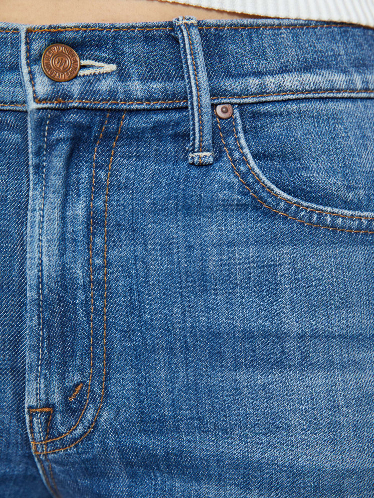 Swatch view of a woman in a mid blue high-rise straight-leg jeans with an ankle-length inseam and a clean, cuffed hem.