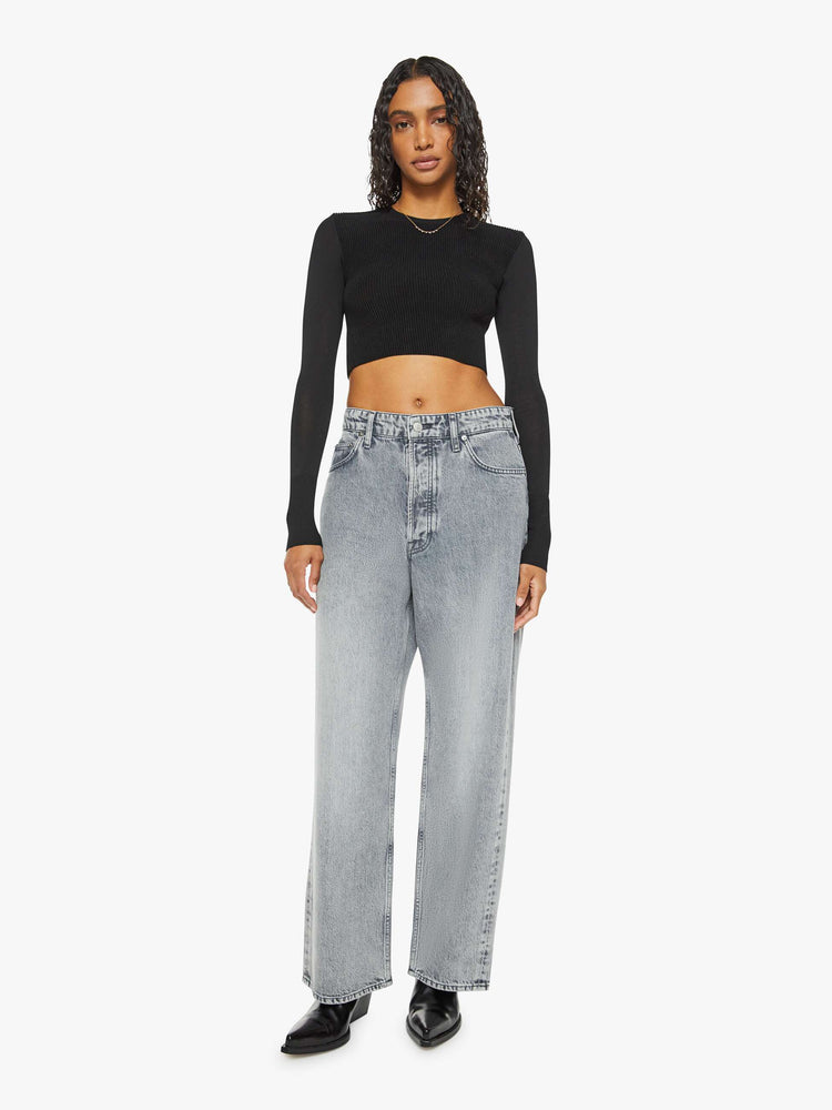 Front view of a woman in a grey wide leg super high-waisted jeans have a 29-inch inseam and a loose, slightly baggy fit.