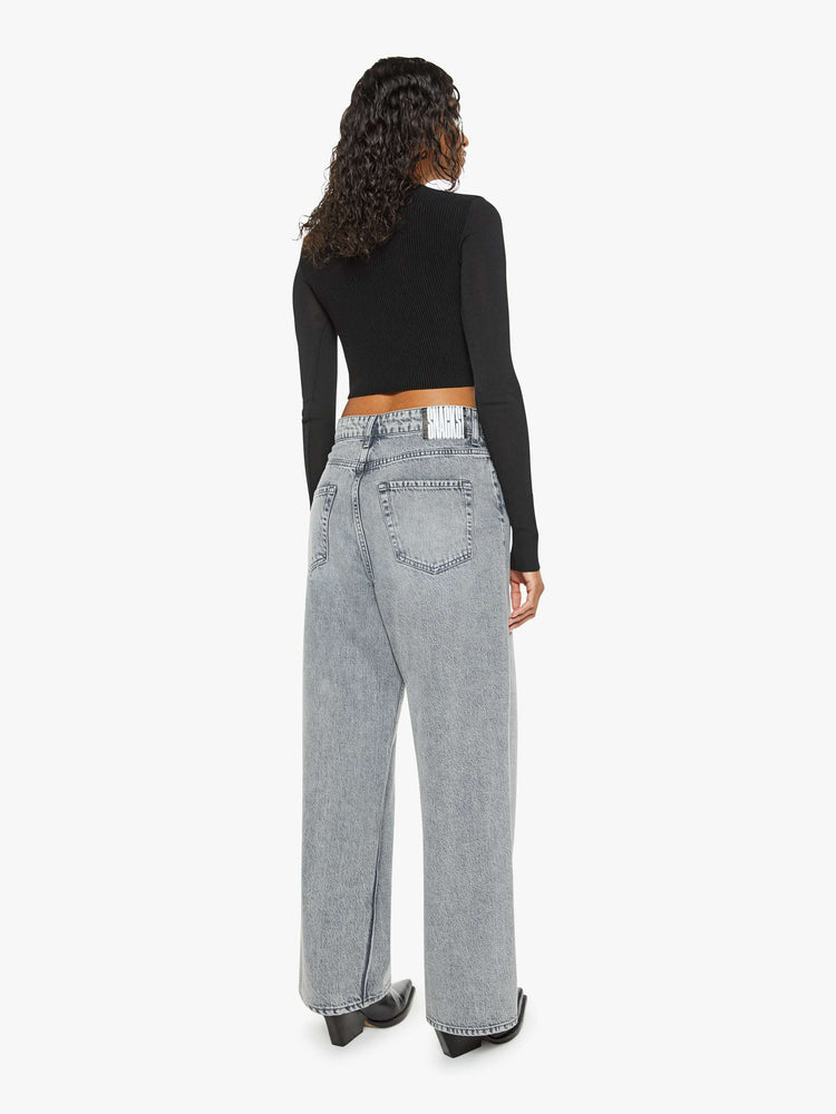 Back view of a woman in a grey wide leg super high-waisted jeans have a 29-inch inseam and a loose, slightly baggy fit.