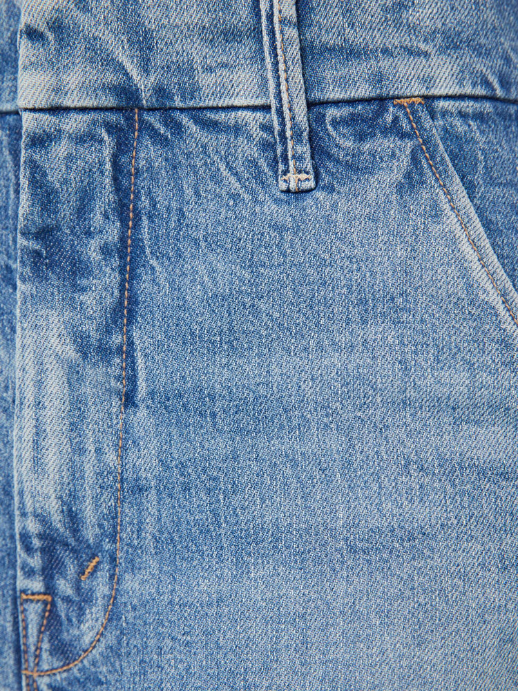 Swatch view of a woman in light blue high rise jeans that sit lower with slit pockets and a clean hem. 