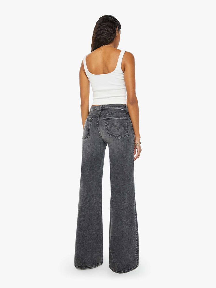 Back view of a woman dark grey flared, wide-leg jean with a mid rise and a clean, 34-inch inseam.