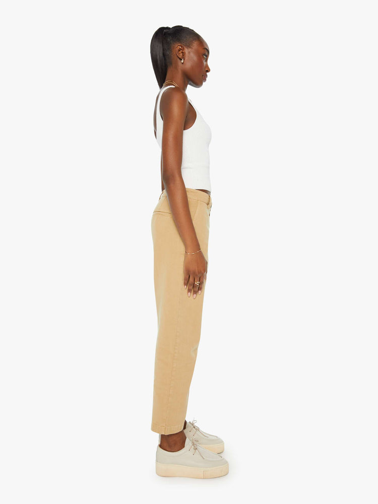 Side view of a woman in khaki slouchy straight-leg pants with a super high rise, slit pockets and a cropped inseam.