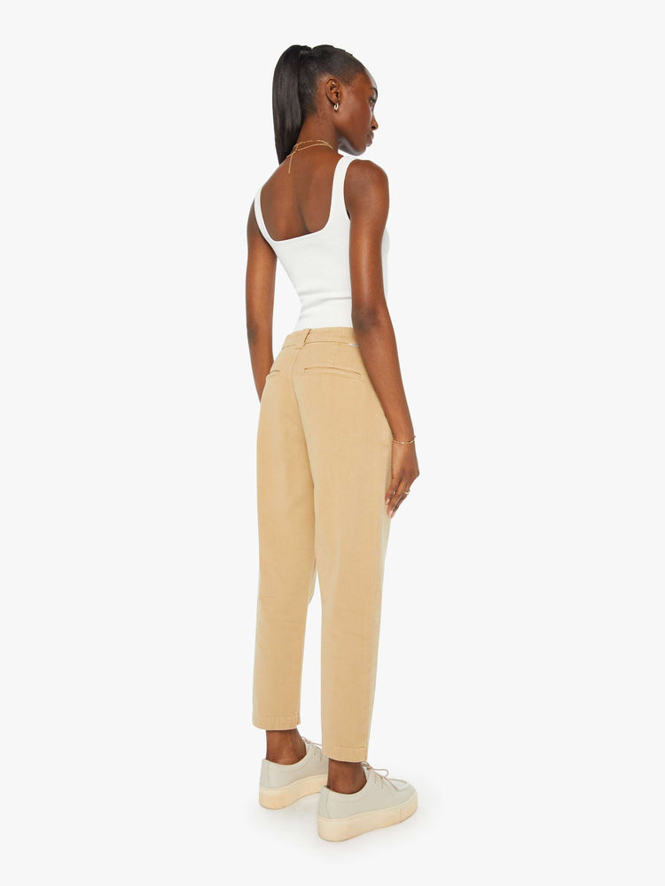 Back view of a woman in khaki slouchy straight-leg pants with a super high rise, slit pockets and a cropped inseam.