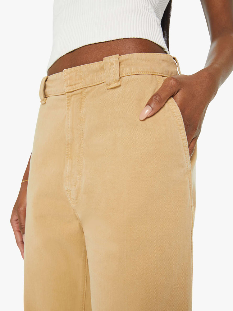 Detailed view of a woman in khaki slouchy straight-leg pants with a super high rise, slit pockets and a cropped inseam.