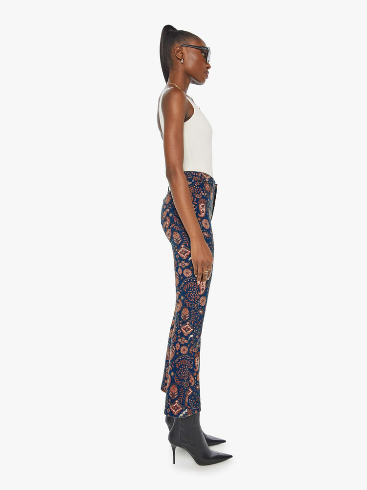 Side view of a woman in a navy pink paisley high-waisted bootcut with a 28.25-inch inseam and a clean hem.