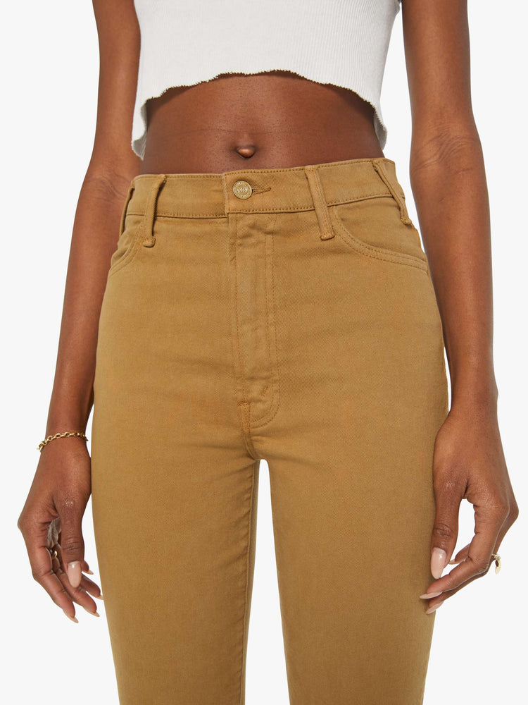 Close up view of a woman in a khaki pant with a high-rise flare has a 28.25-inch inseam and a clean hem.