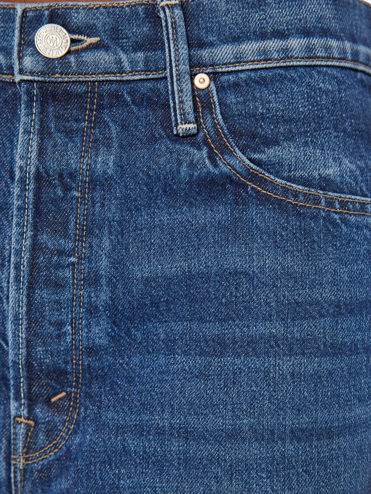 Swatch view of a woman in low rise dark blue straight-leg jeans with a cuffed hem.