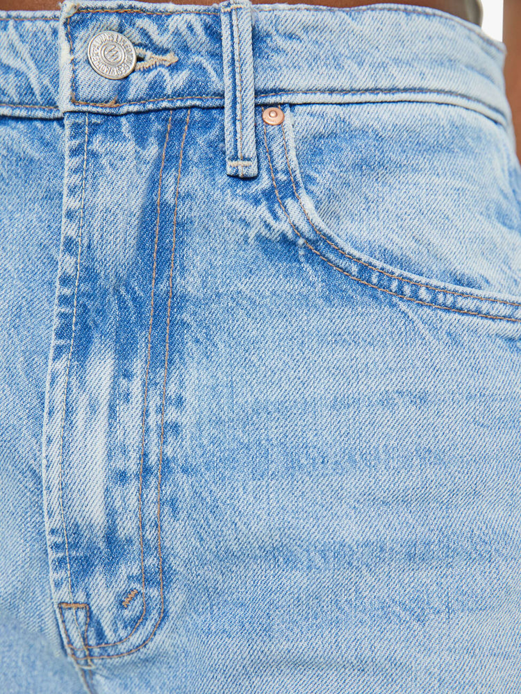 Front close up view of a a light blue wash jean with contrast brown thread.