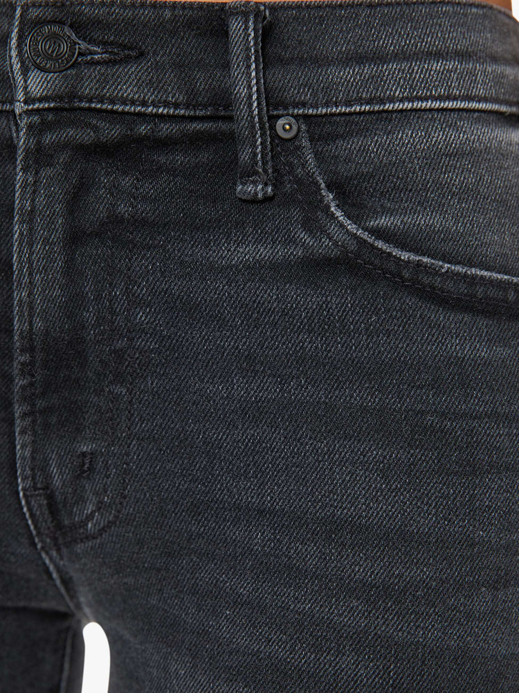 Swatch view of a woman in a black wash bootcut jeans with a mid rise and a 29.25-inch inseam with a clean hem.