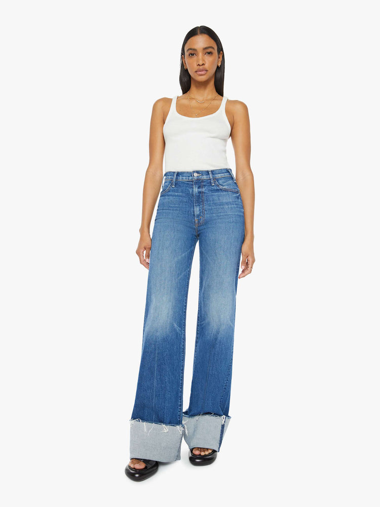 Front view of a woman wide leg jeans with a high rise, long 34-inch inseam and an oversized cuffed hem that's frayed in medium blue wash. 