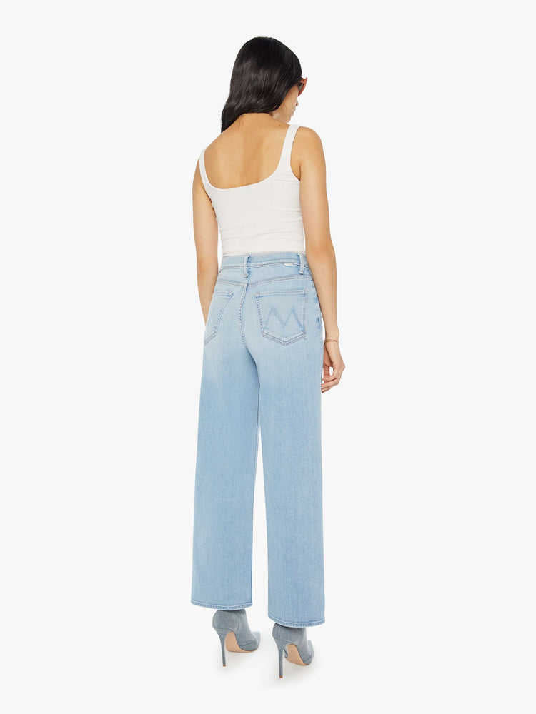 Back view of a woman Super high-rise jeans with a loose wide leg, zip fly and a 28.25-inch inseam with a clean hem in a light blue wash.