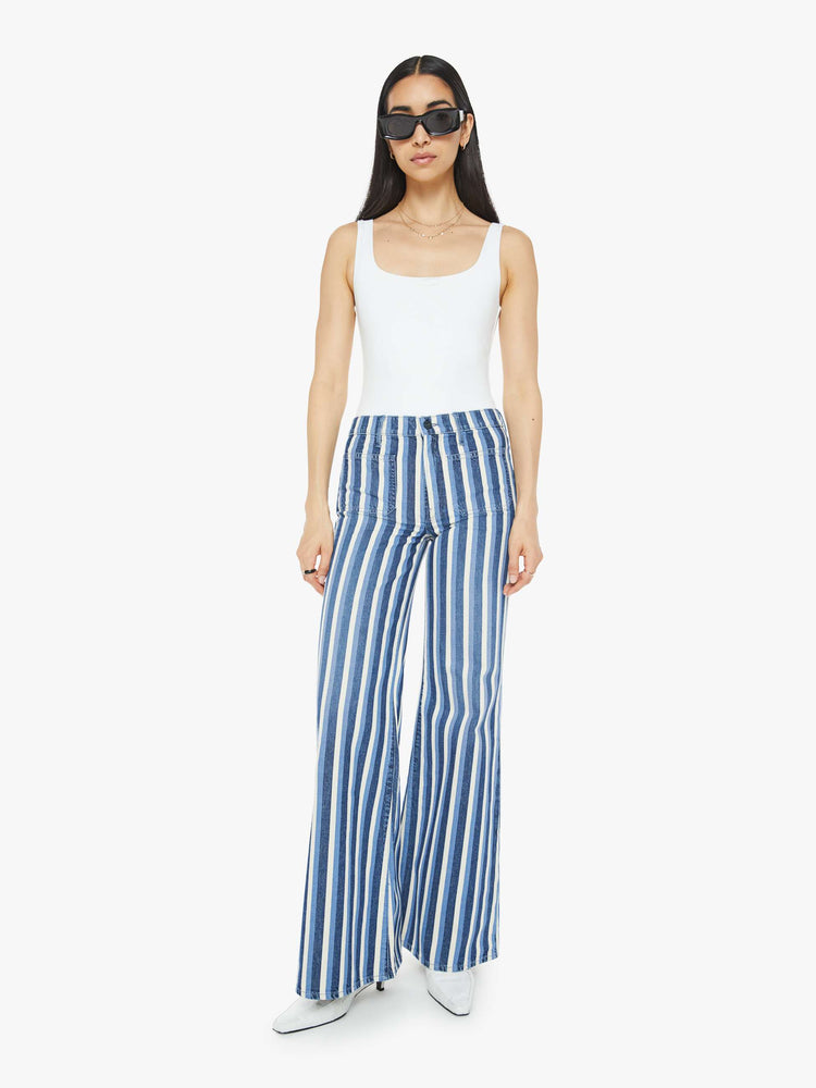 Front view of a woman in a flared,  wide-leg pants with patch pockets and a long 32-inch inseam with a clean hem in white and light blue stripes.