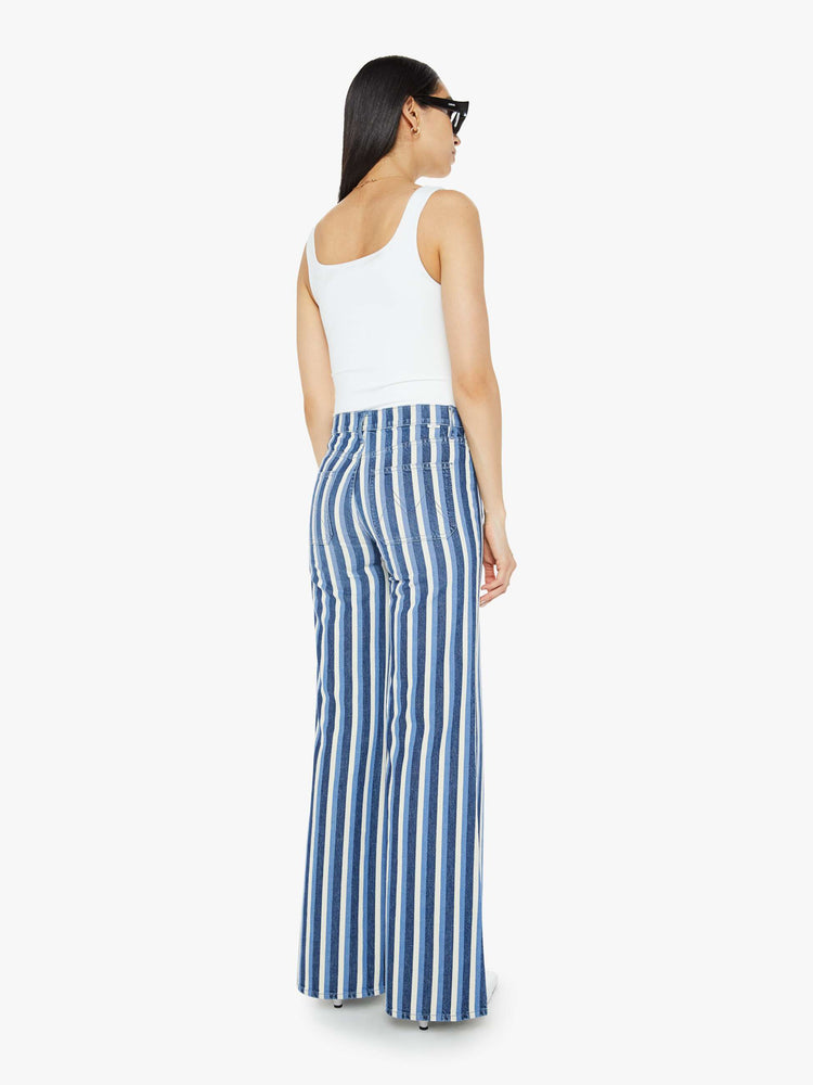 Back view of a woman in a flared,  wide-leg pants with patch pockets and a long 32-inch inseam with a clean hem in white and light blue stripes.