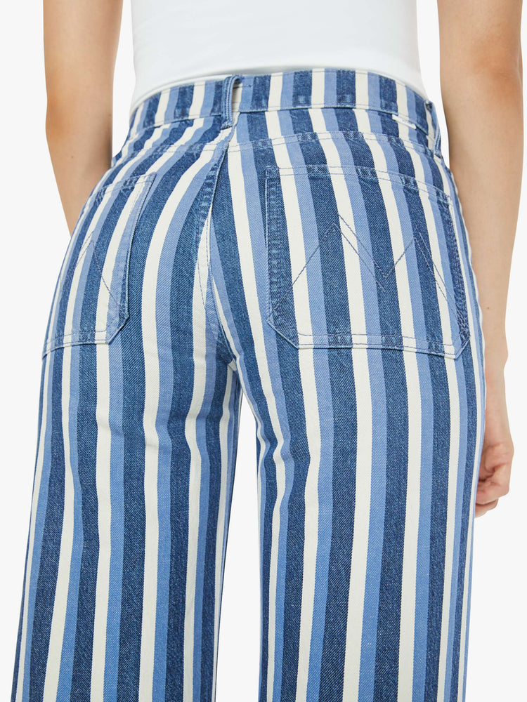 Close up view of a woman in a flared,  wide-leg pants with patch pockets and a long 32-inch inseam with a clean hem in white and light blue stripes.