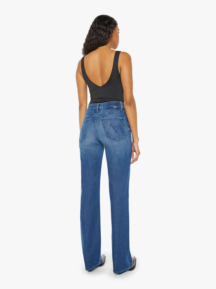 Back view of a woman med blue high-rise jeans with a wide straight leg, zip fly and a long 34-inch inseam with a clean hem.