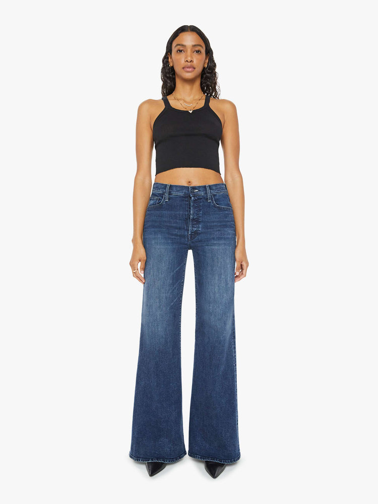 Front view of a dark blue high-waisted wide leg has a button fly, 32-inch inseam and clean hem.