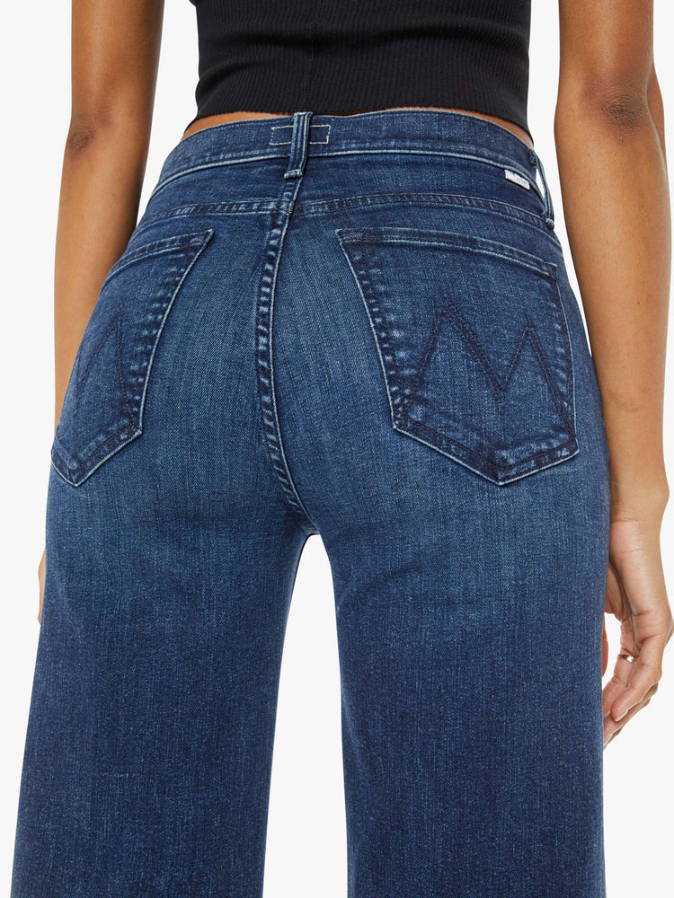 Close up back view of a dark blue high-waisted wide leg has a button fly, 32-inch inseam and clean hem.