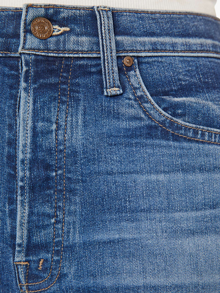 Swatch view of a woman in mid blue wash high-rise flare with a button fly and 28.25-inch inseam with a clean hem.