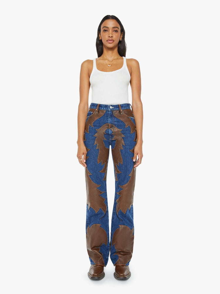 Front view of a woman super high-waisted bootcut jeans with a 34-inch inseam and clean hem in a dark blue wash with a faux leather applique.