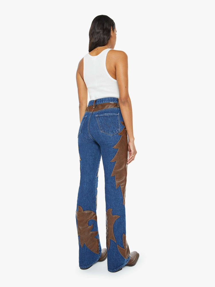 Back view of a woman super high-waisted bootcut jeans with a 34-inch inseam and clean hem in a dark blue wash with a faux leather applique.