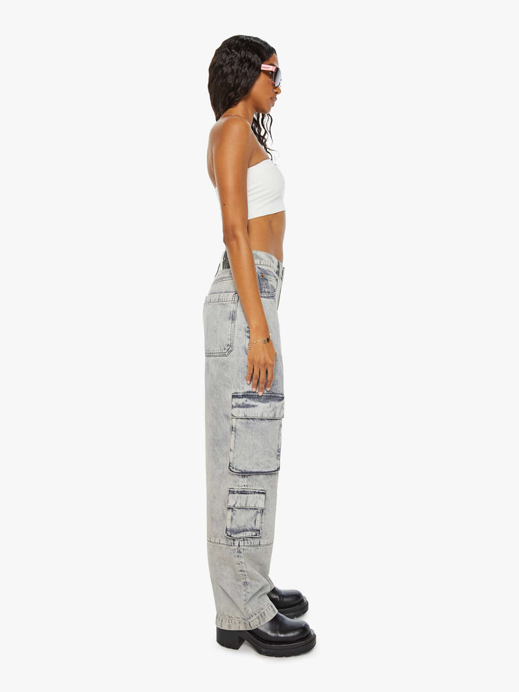 Side view of a woman in acid-washed grey wide-leg pants feature a super high rise, long 31-inch inseam, cargo-inspired patch pockets and a loose, slightly baggy fit.